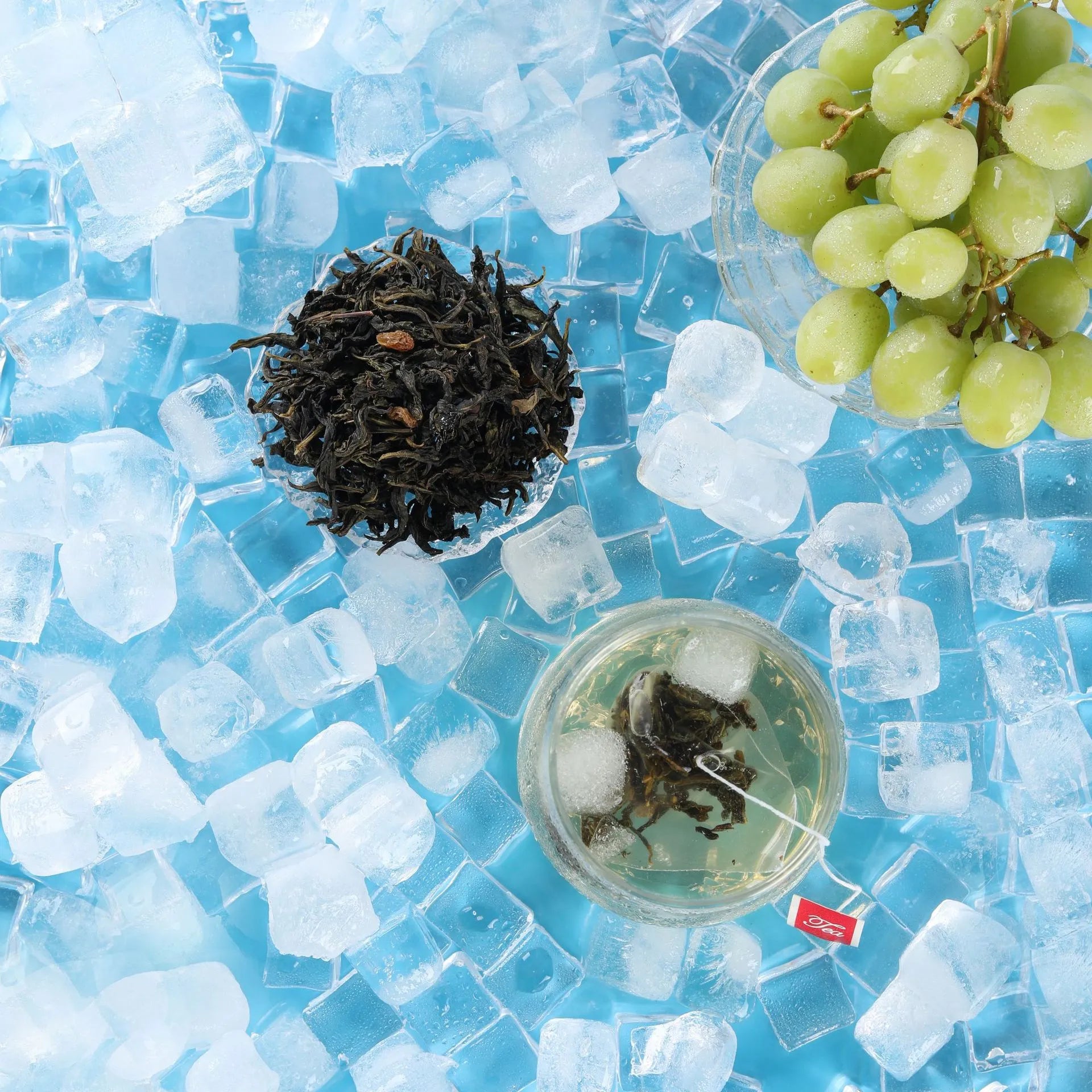 Glass of cold brew grape oolong tea with tea leaves and green grapes on ice
