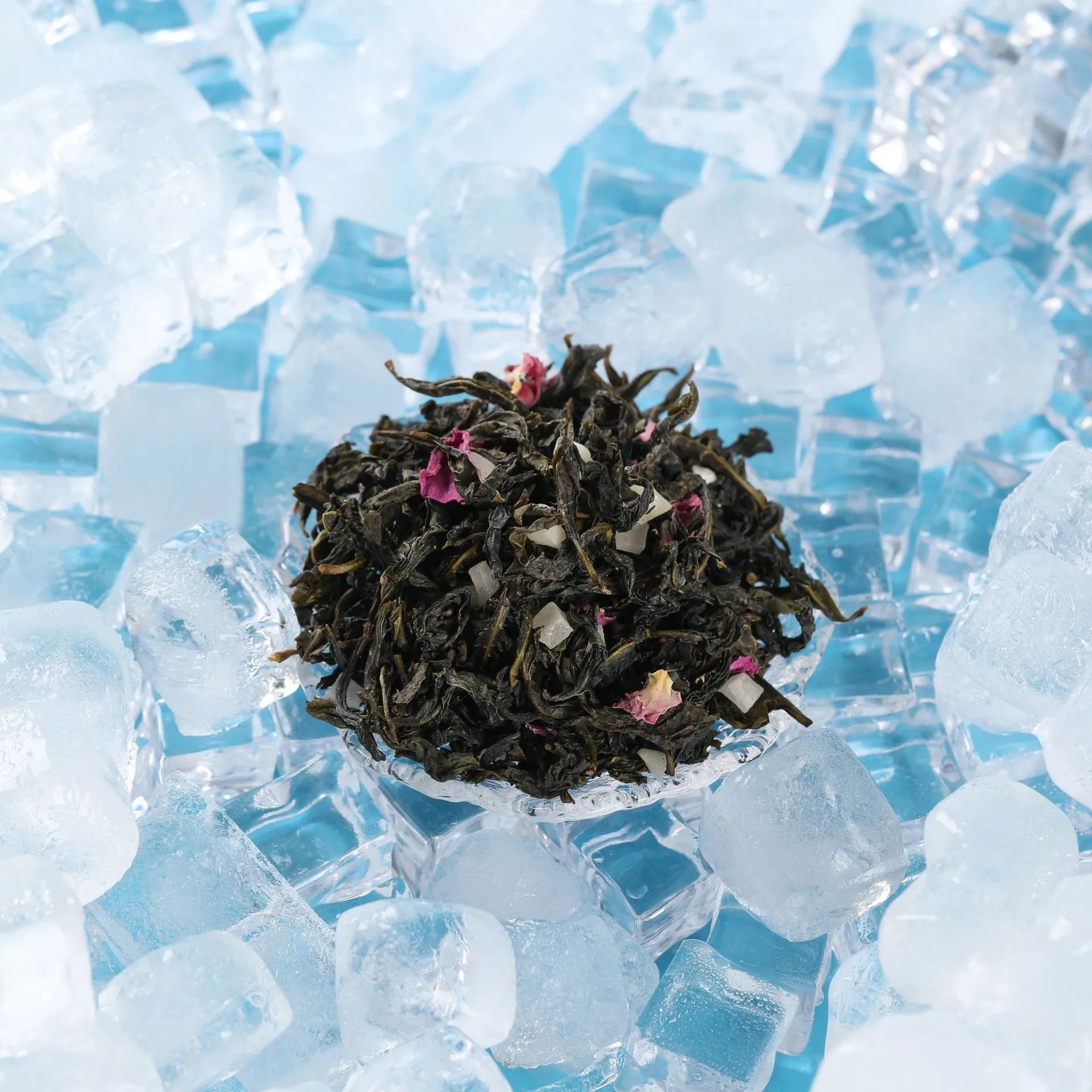 White peach oolong tea leaves on ice, with visible rose petals and fruity bits for a refreshing presentation