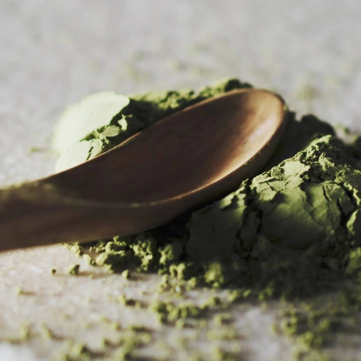 Bamboo spoon resting on vibrant Leafmill matcha powder, representing the traditional preparation of matcha tea.