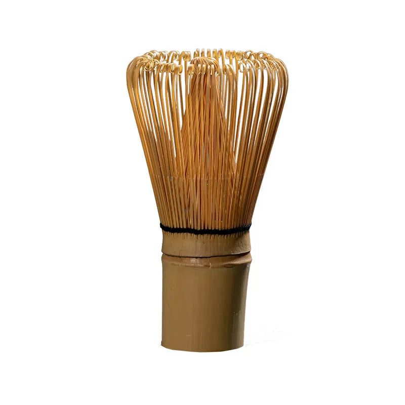Traditional bamboo chasen (matcha whisk) with fine, handwoven bristles, a central knot, and a black twine-wrapped handle, isolated on a white background.