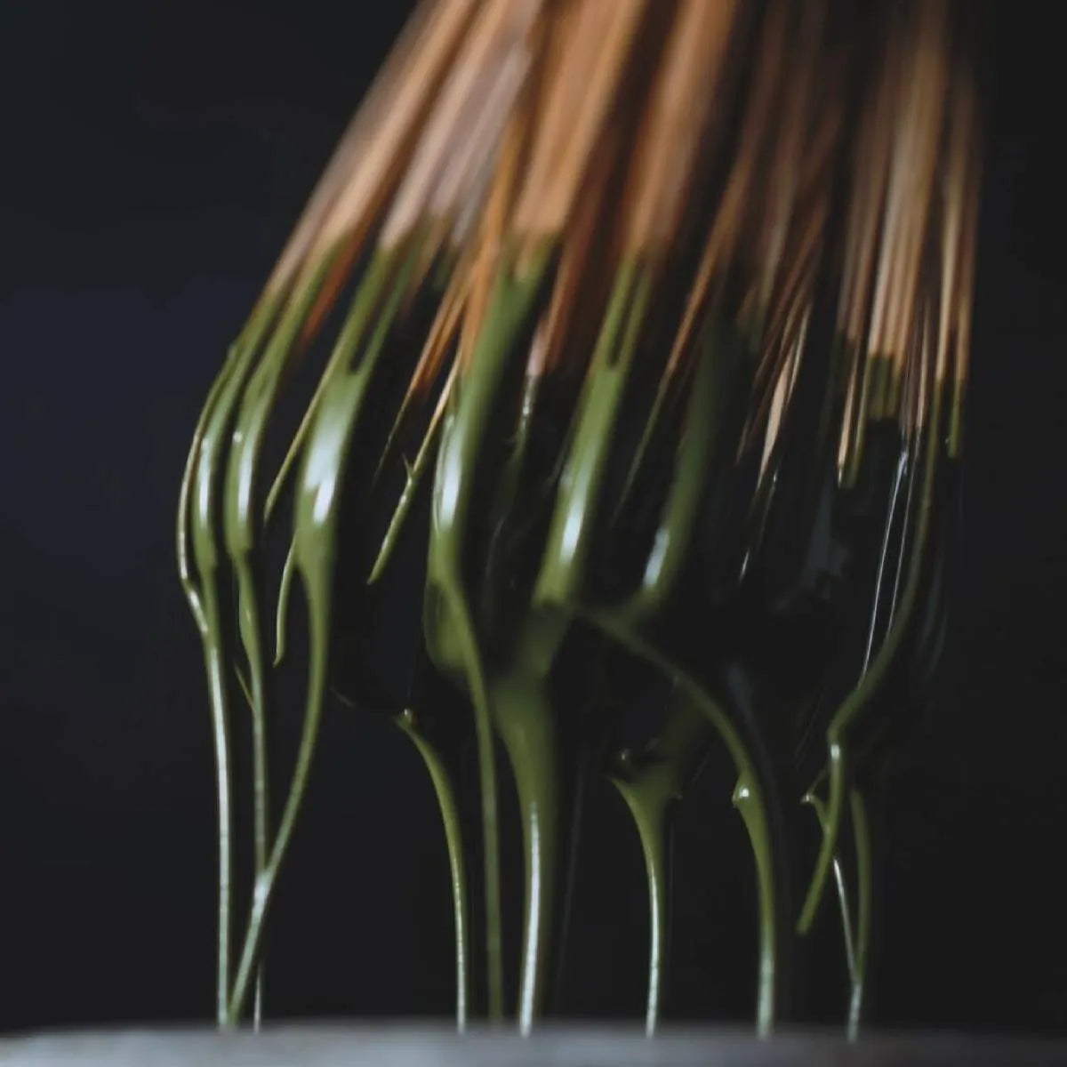 Close-up of a traditional bamboo whisk coated with thick, vibrant Leafmill matcha, representing the essence of matcha.