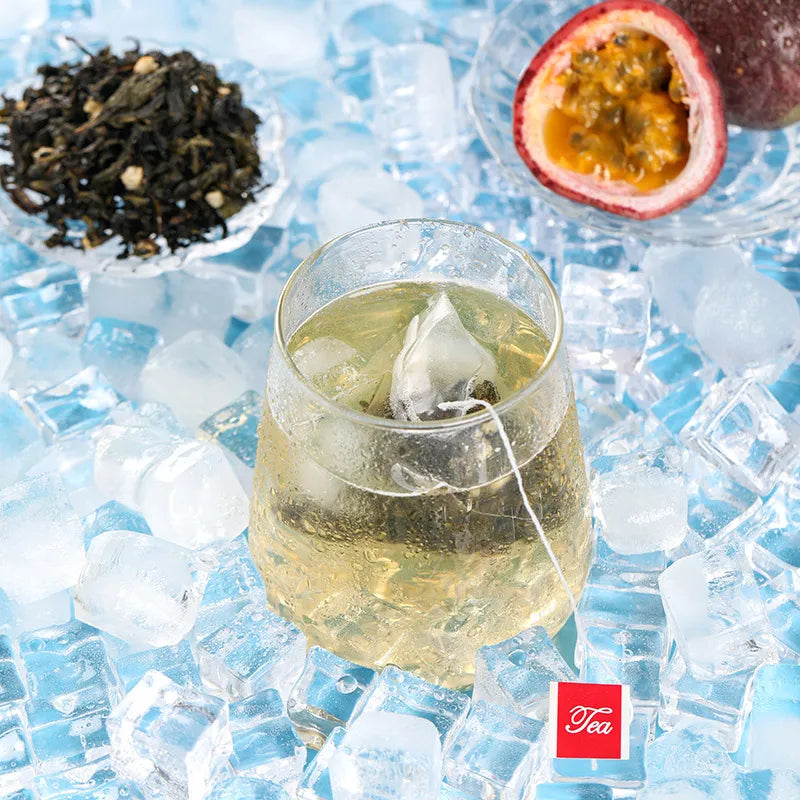 Top view of a refreshing passion fruit oolong cold brew tea served over ice, with loose tea leaves and passion fruit in the background.